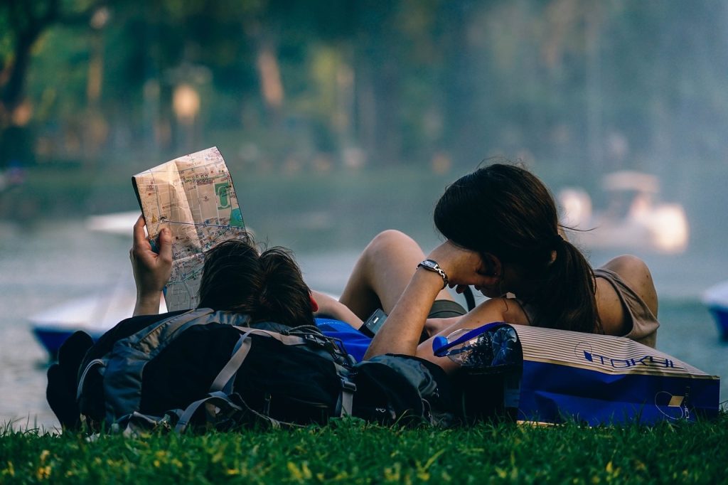 A couple resting on their backpacks
