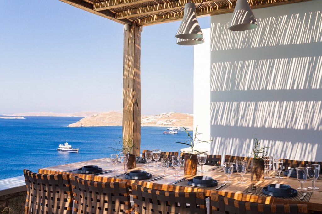 Luxury retreat: Mykonos villa with open area, lunch table, and panoramic sea view.