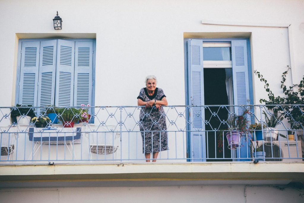 An older woman standing on the balcony