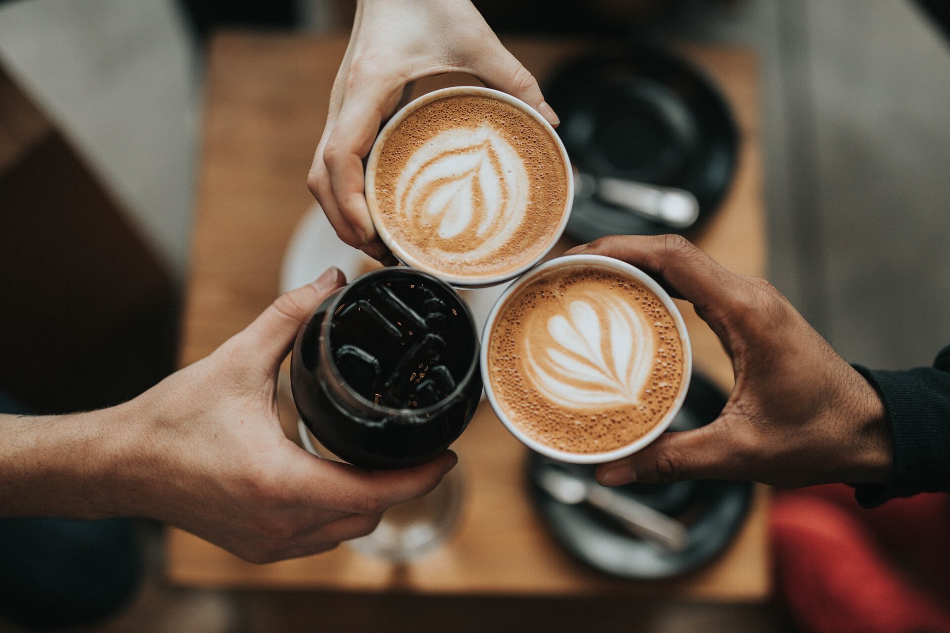 People cheering with coffee cups