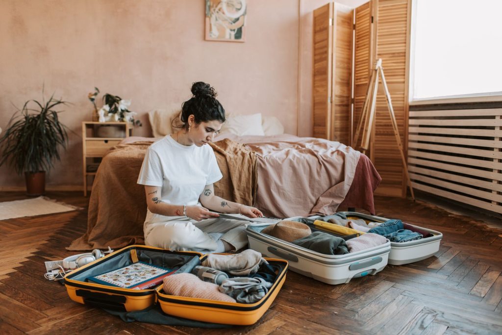 Woman sitting on the floor and looking at the luggage