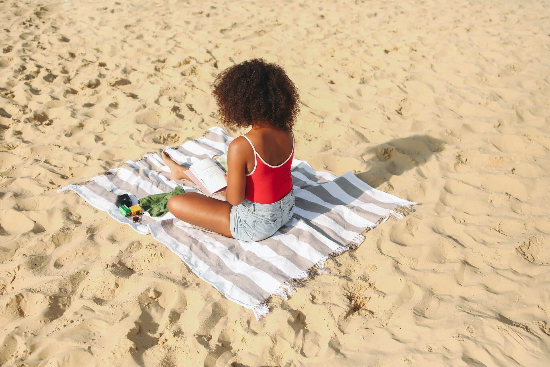 Woman sitting on a beach and reading