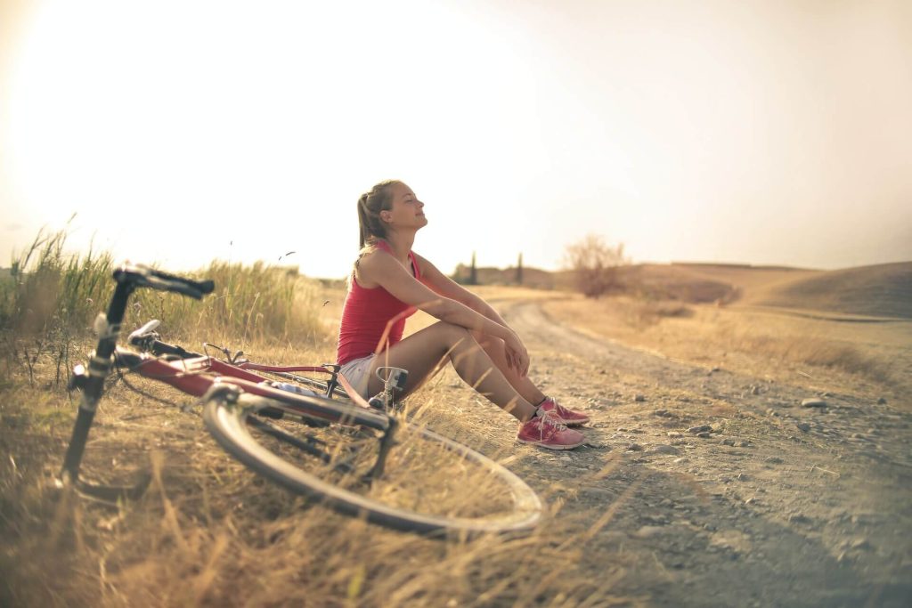 Woman resting next to a bicycle