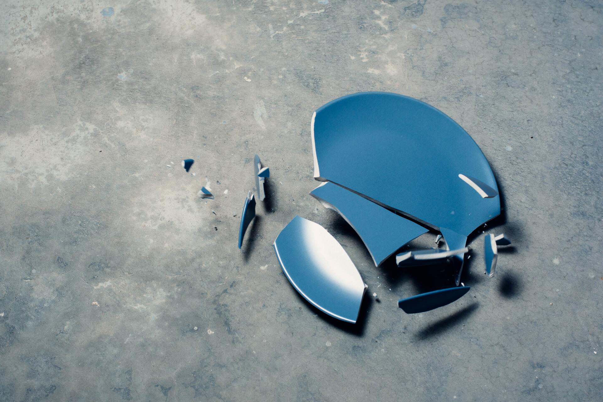 A broken blue plate on the floor