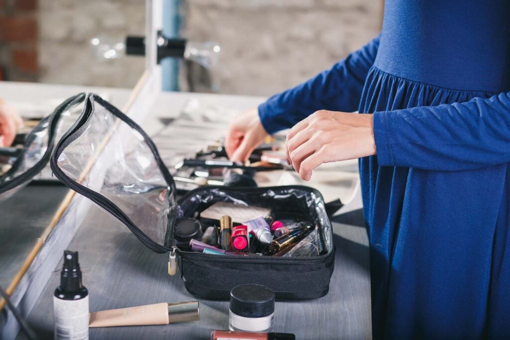 A woman packing a makeup bag