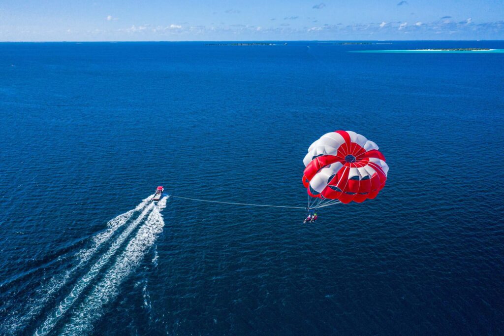 People parasailing attached to a boat 
