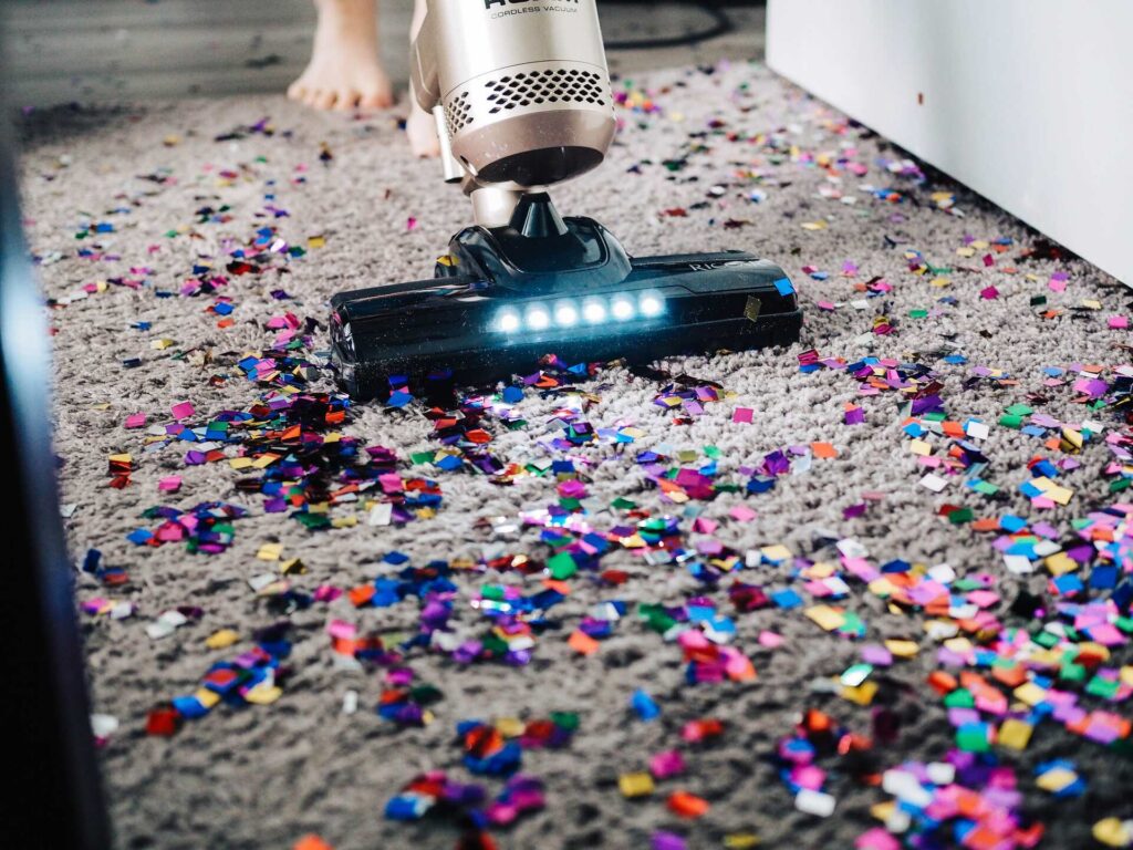 A person vacuuming confetti 