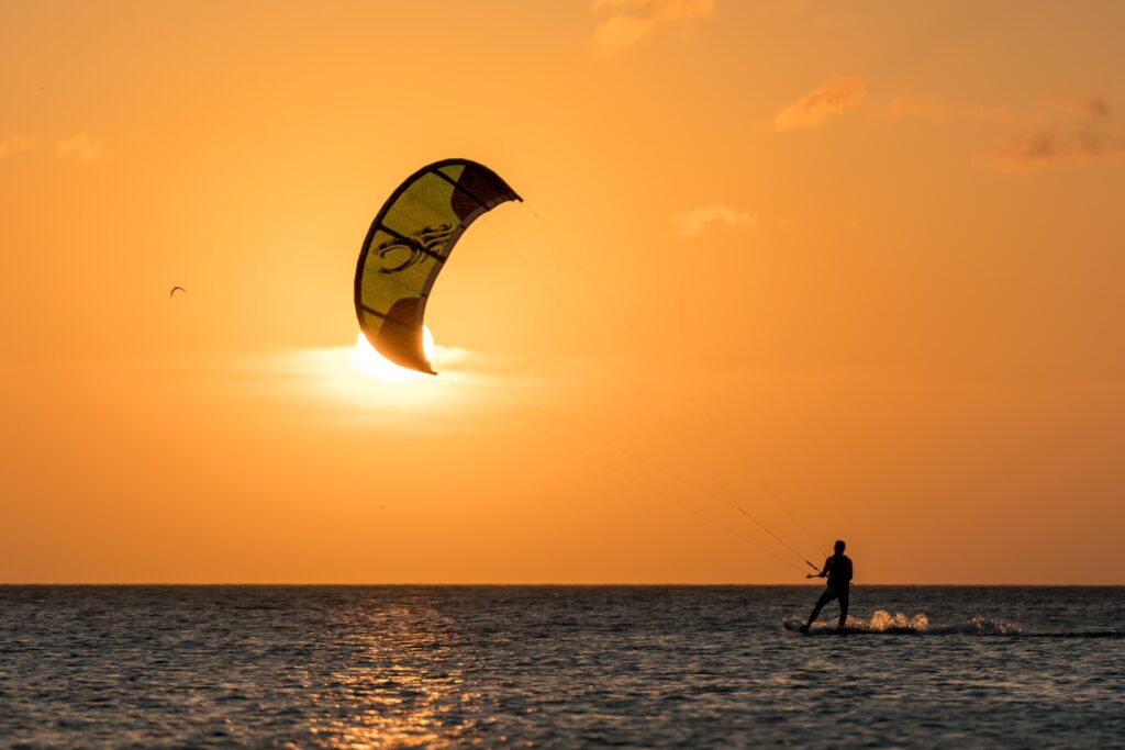 A person kitesurfing in the sunset 