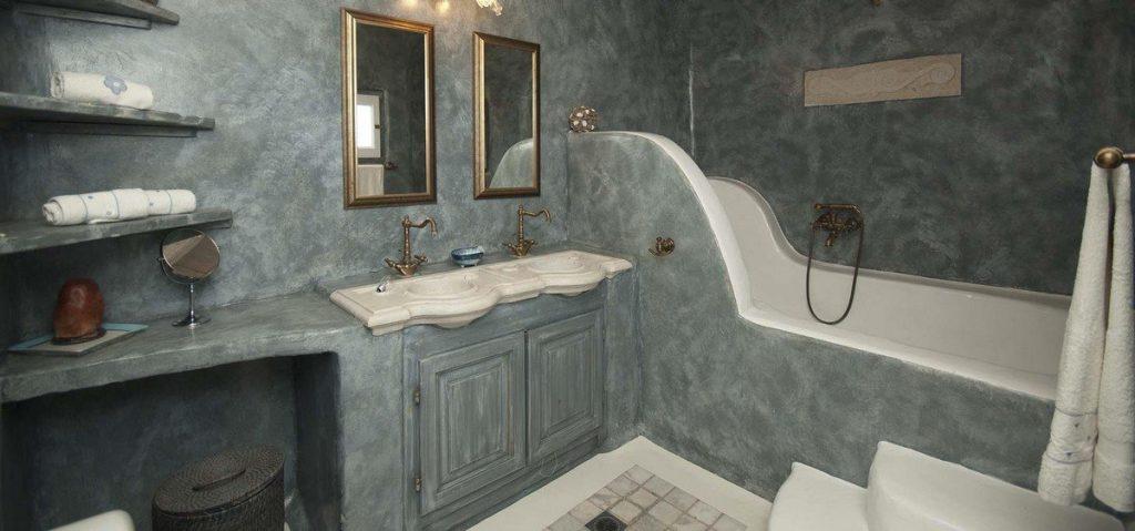 grey wall bathroom with bath and soft towels on shelf