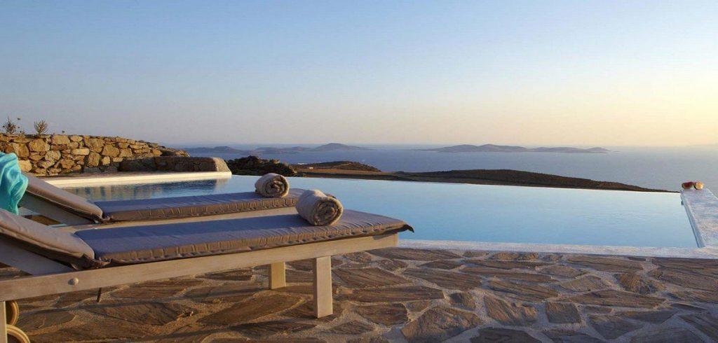 Villa Valery, Fanari, Mykonos, outdoor rest area, stone deck, sunbeds, towels, stone wall, swimming pool, panoramic sea view