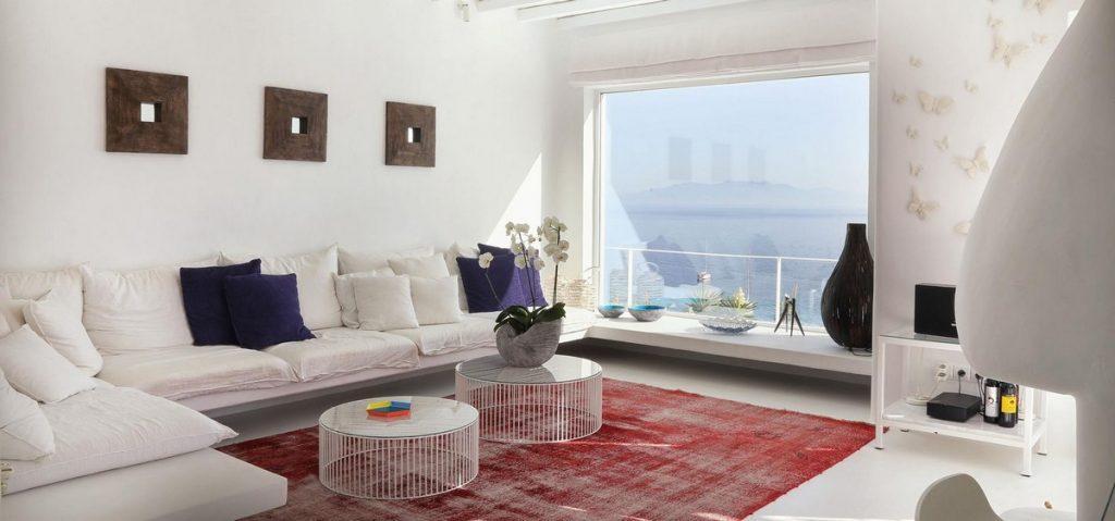 spacious living room with big sofa faced directly at window wall sea view
