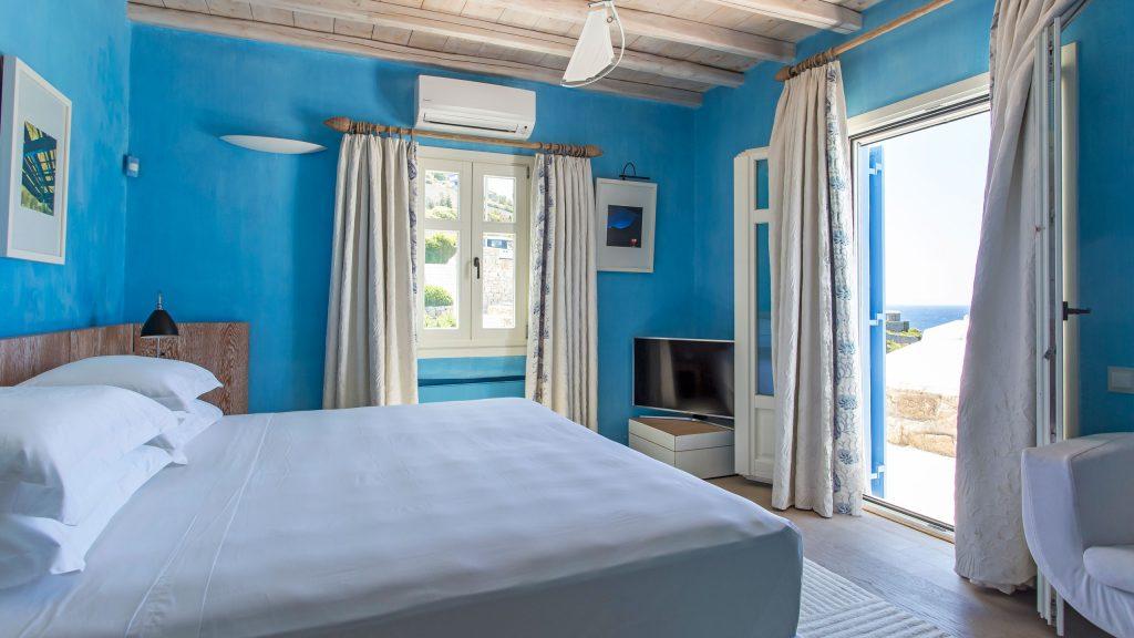 blue wall bedroom with huge soft bed and air condition