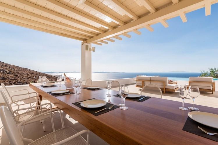 Villa_Ales_08.jpg Fanari Mykonos Outdoor Dining area, table, plate, glass, fork, knife, pool, bed, sea, sky, hill, horizon