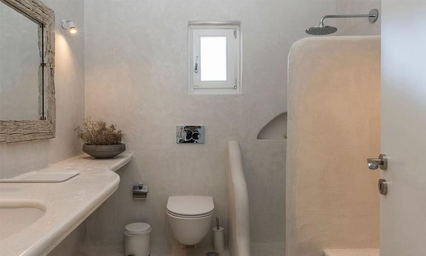 bathroom with wooden frame mirror wall lamp and ceramic sink