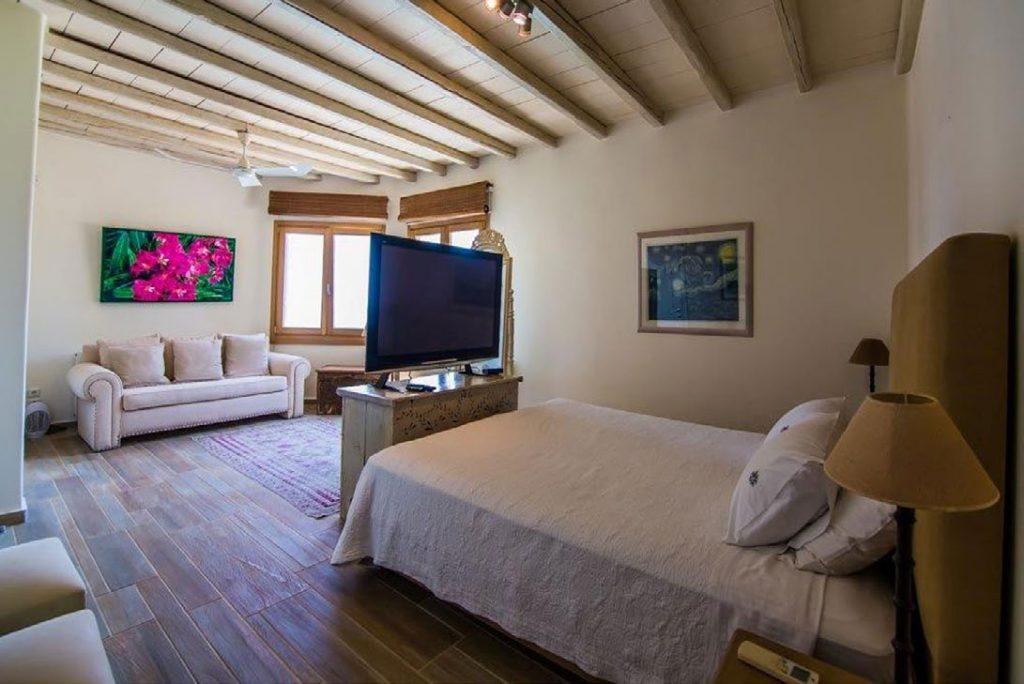 Villa Felicia Agios Lazaros Mykonos, 3rd bedroom, bed, flat screen TV, paintings, sofa, pillows, windows