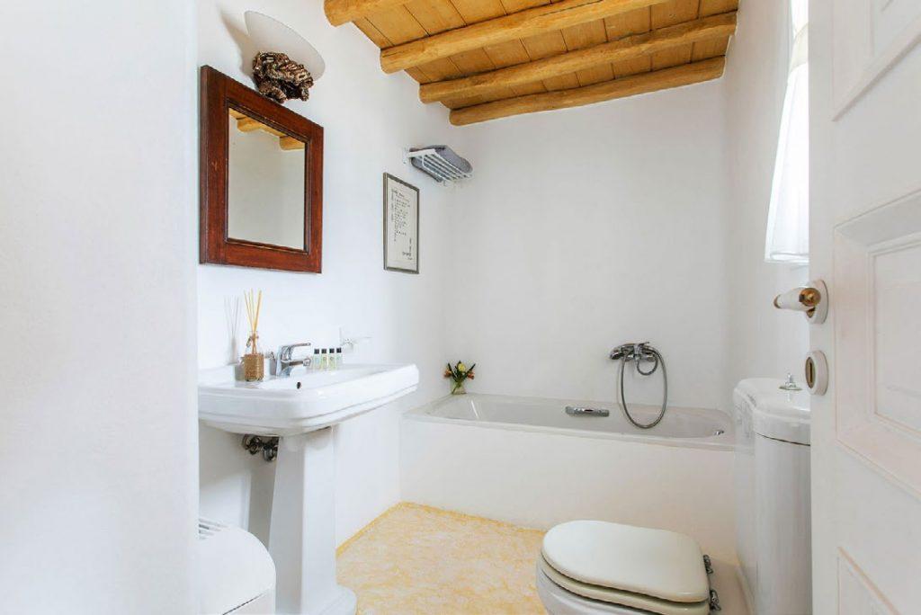 bathroom with wooden mirror frame and toilet