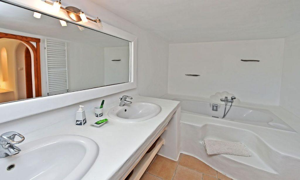 white wall bathroom with huge mirror and bath