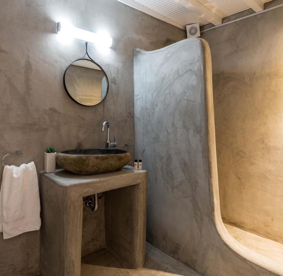 minimal designed bathroom with rock sink and grey shower