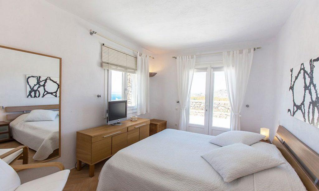 cozy room with comfortable bed and soft pillows for resting and watching beautiful mykonos view