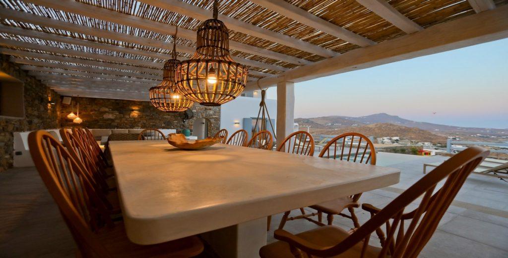 Villa-Ragnar_05.jpg Kalafatis Mykonos, outdoor dining area, dining table, chairs, lights, bowl