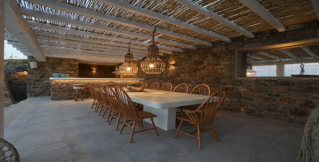 Villa-Ragnar_06.jpg Kalafatis Mykonos, outdoor dining area, dining table, chairs, bar, lights
