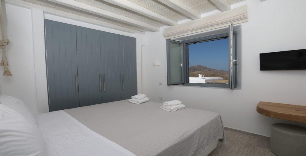 Villa-Ragnar_21.jpg Kalafatis Mykonos, 6th bedroom, window, flat screen TV, king size bed, towels, closet