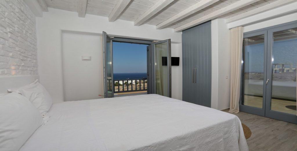 Villa-Ragnar_23.jpg Kalafatis Mykonos, 5th bedroom, king size bed, closet, curtains, door, carpet, pillows