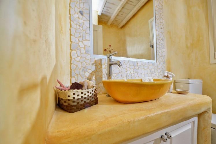 yellow wall bathroom with ceramic sink and basket