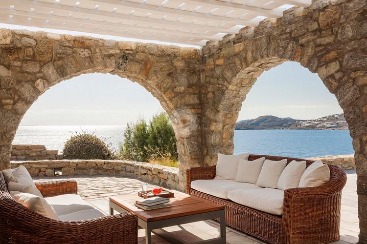 Villa_Jolly_23.jpg Agios Lazaros Mykonos Outdoor Living area, bed, pillows, table, book, glass, sea, sky, hill