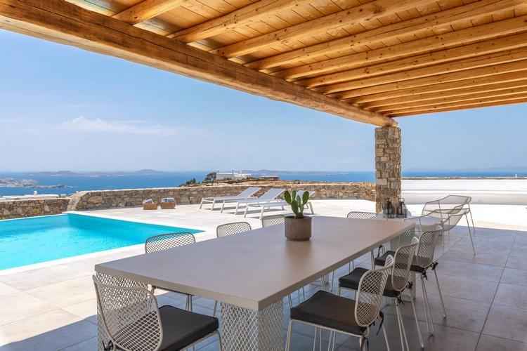 Villa_Madona_08.jpg Tourlos Mykonos Outdoor Dining area, table, flowers, chairs, pool, sea, sky, horizon