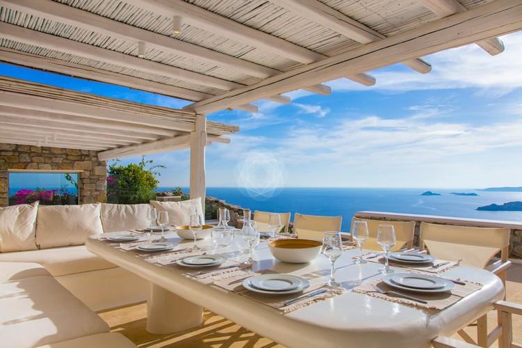 Outdoor dining area with a white table and the sea in the distance