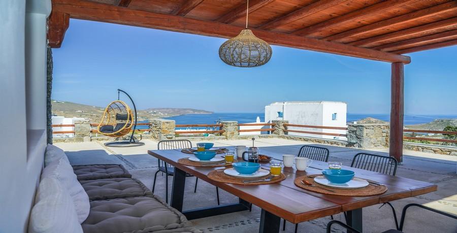 Villa_Sofy_09.jpg Kalafatis Mykonos Outdoor Dining area, table, bench, pillows, lamp, plate, balcony