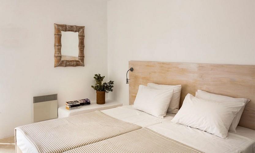 bedroom with wooden bed frame and small wall mirror
