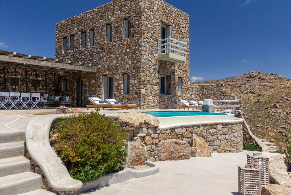 Villa-Camelia_08.jpg Agrari Mykonos, villa exterior, pool, climbers, chair, dining table ,stairs, sky