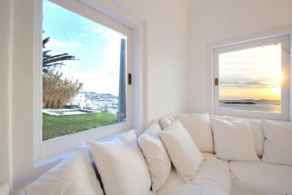 Villa-Parthenia_11.jpg Chora Mykonos, living room, windows, sea view, sun, island view, sofa, pillows