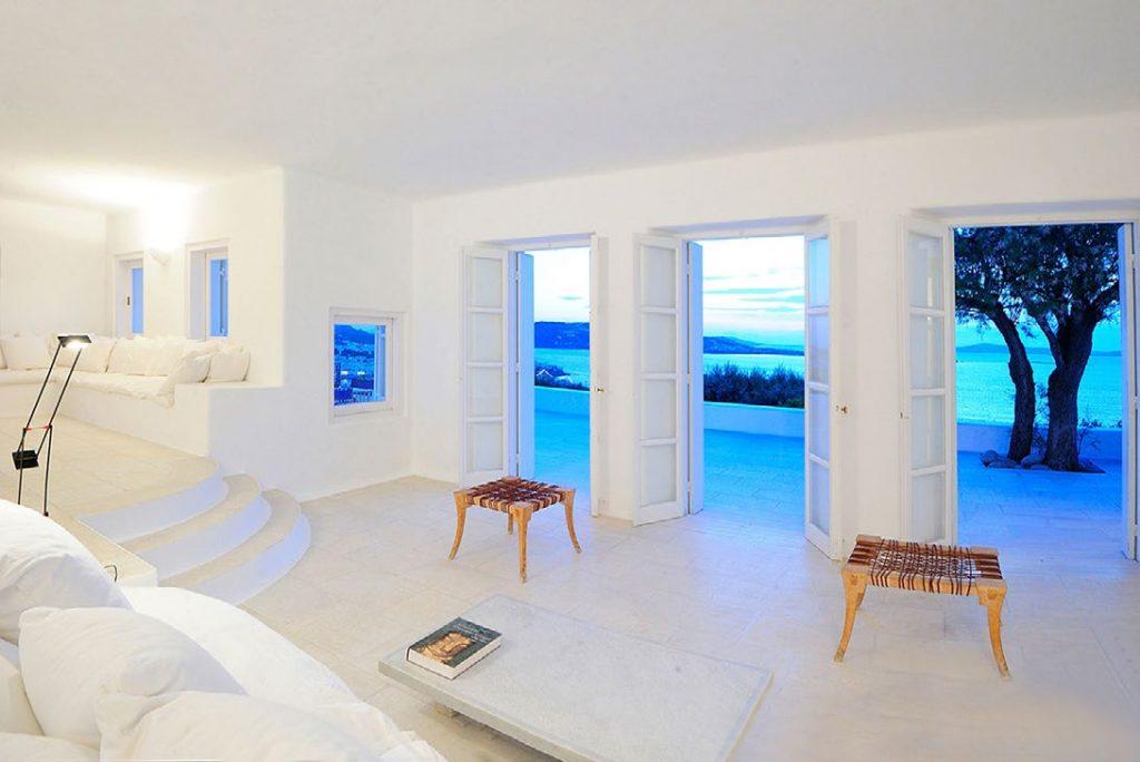 Villa-Parthenia_12.jpg Chora Mykonos, living room, table, book, outdoor view, sea, stairs, sofa, pillows