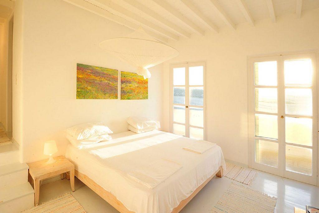 Villa-Parthenia_15.jpg Chora Mykonos, 1st bedroom, king size bed, paintings, nightstand, lamp, carpets, pillows, towels