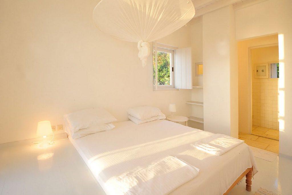 Villa-Parthenia_16.jpg Chora Mykonos, 2nd bedroom, king size bed, pillows, towels, lamps, nightstand, shelves, window