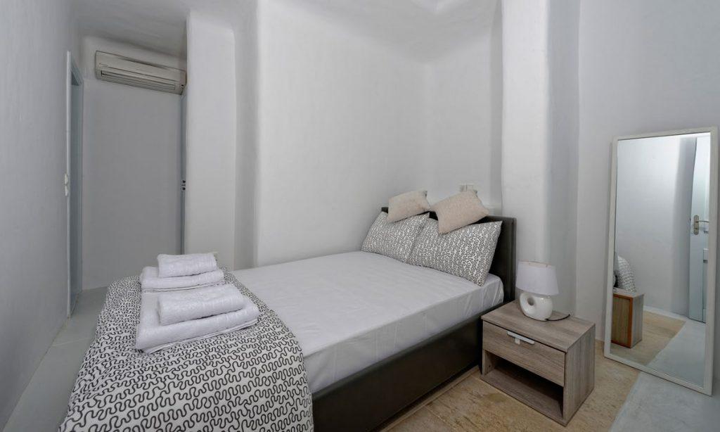 Villa-Valence-_27.jpg Kalafatis Mykonos, 4th bedroom, bed, towels, robes, pillows, nightstand, lamp, mirror, AC