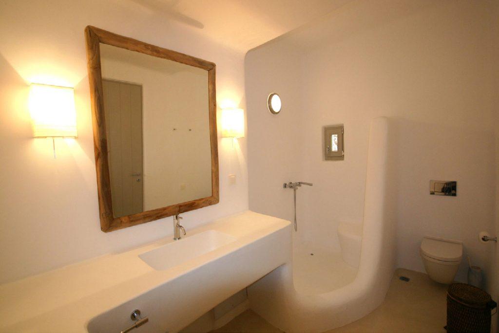 bathroom with wall lamp for light and shower with small window