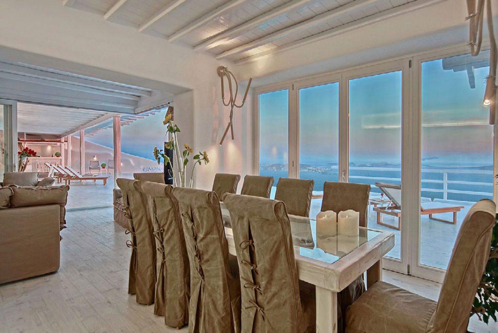 elegant dining room with candles and flowers, and out door view of sea