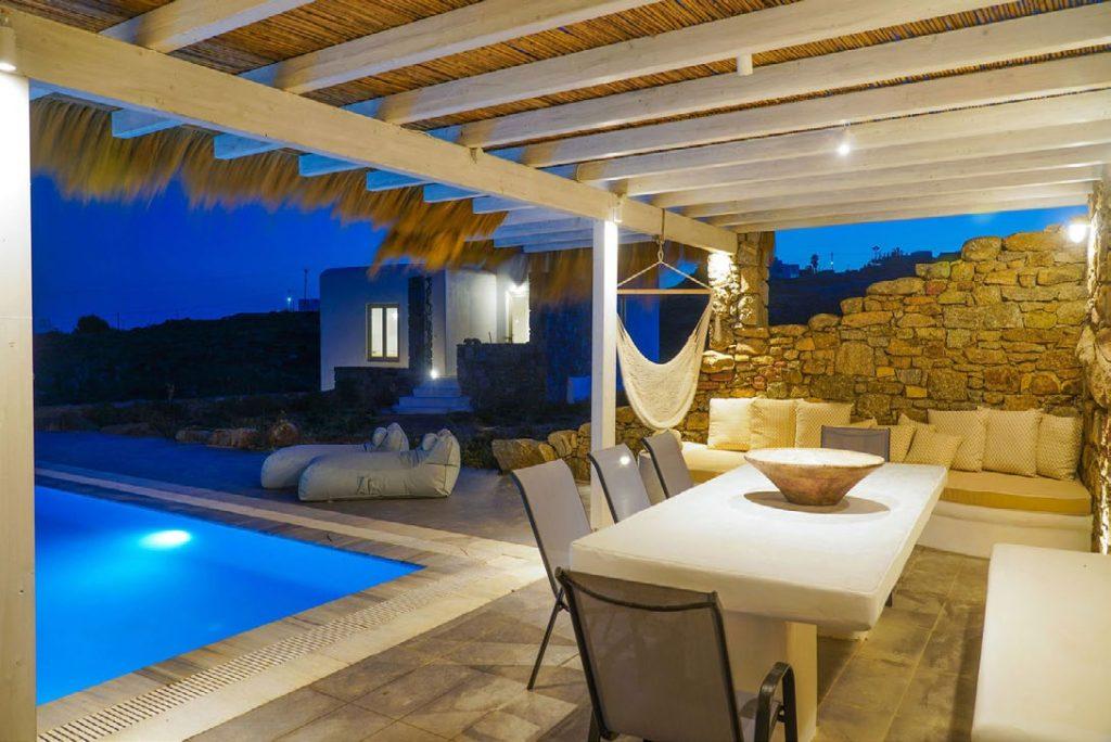 Villa Umabel, Agios Stefanos, Mykonos, Swimming pool, Pool, Stone wall, Balcony, Chairs, Lazy bag, Sky, White villa, Plams