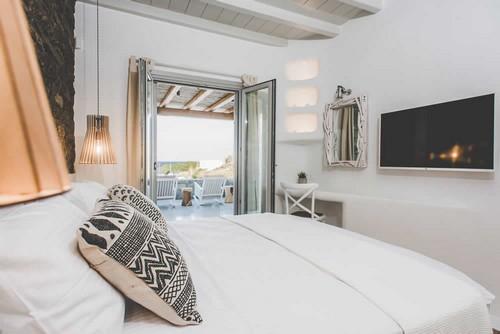 Villa_Levi_10.jpg Chora Mykonos 3rd Bedroom, bed, flat screen tv, shelf, pillows, lamp, night table, chair