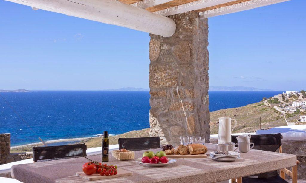 Villa Orion Retreat, Houlakia, Mykonos, outdoor, dining area, dining table, sea, sky, glasses, food, fruit