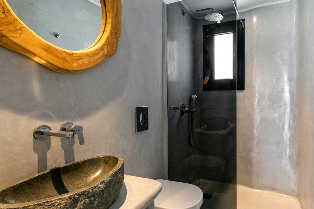 bathroom with glass shower and unique designed mirror