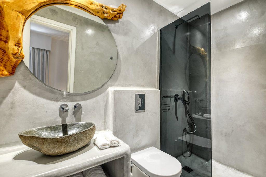 bathroom with round mirror and ceramic sink