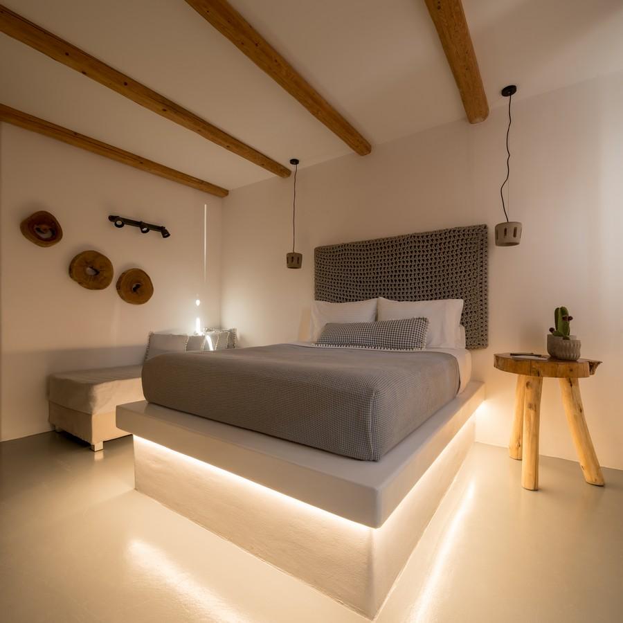 nice lit bedroom with night wooden stand and soft bench