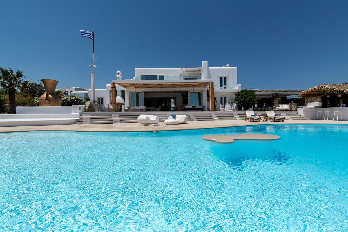 View of the pool and a villa in Mykonos behind it
