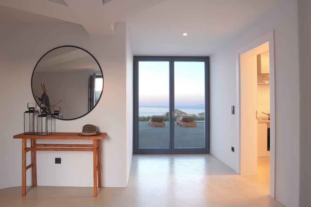 stylish and alluring entryway and hallway with window that gives a view of breathtaking Mykonos sea