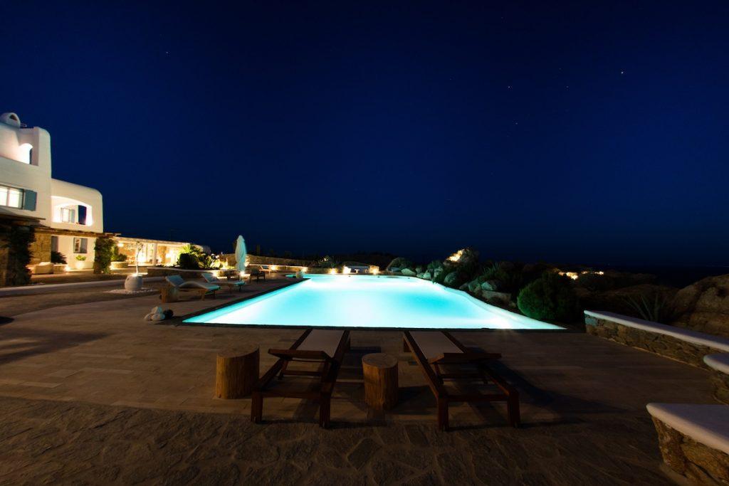 night view of a villa with a lighted pool